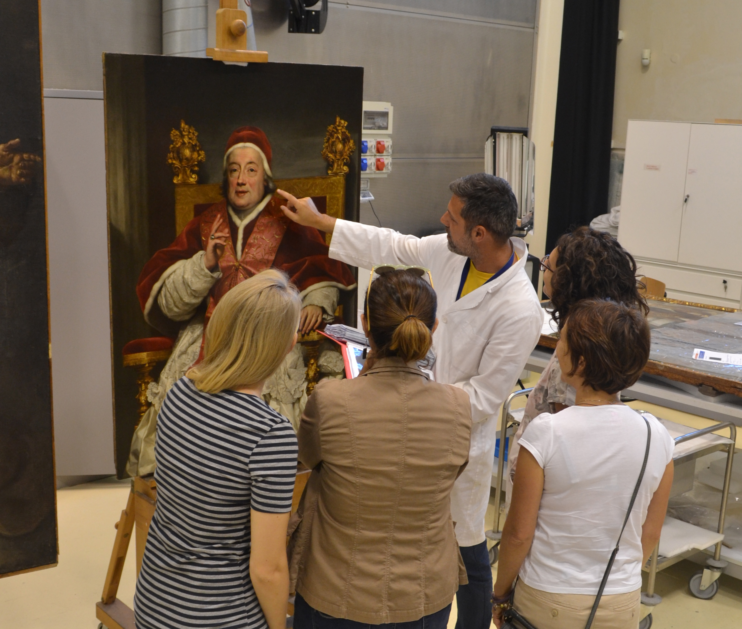 Visit. People with restorer in front of painting